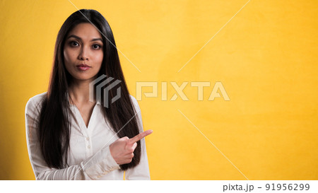 Female asian model points to something Female asian model points to something 91956299