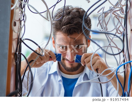 Electrician trying to untangle wires in repair concept Electrician trying to untangle wires in repair concept 91957494