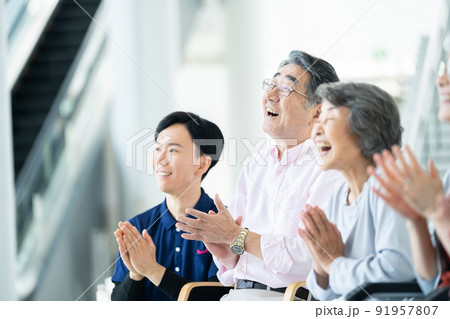 出し物を鑑賞する老人ホーム利用者　シニアイメージ　介護士 91957807