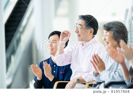 出し物を鑑賞する老人ホーム利用者　シニアイメージ　介護士 91957808