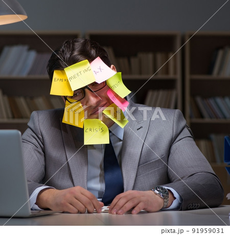 Businessman staying late to sort out priorities 91959031