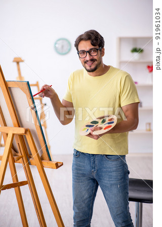 Young man enjoying painting at home 91961034
