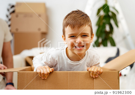 Little boy playing inside a moving box on a moving day Little boy playing inside a moving box on a moving day 91962300