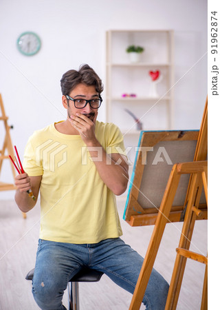 Young man enjoying painting at home Young man enjoying painting at home 91962874