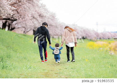 桜並木のある河原沿いを歩く子連れの家族 桜並木のある河原沿いを歩く子連れの家族 91963535