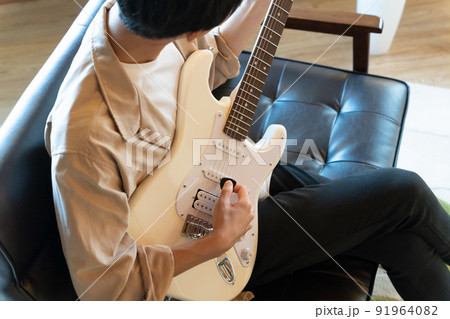 白いエレキギターを弾く若い男性 91964082