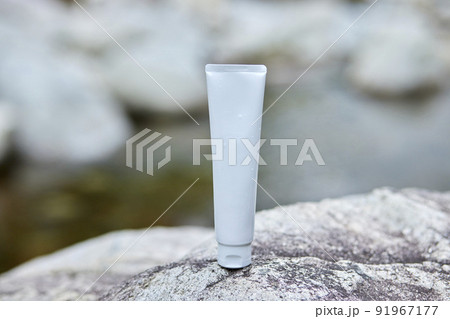 岩の上に置かれた化粧品のチューブ 91967177