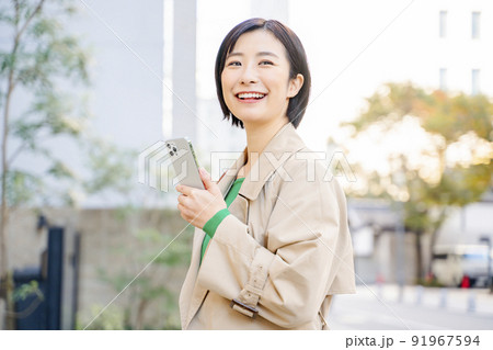 スマホを持つ女性　屋外 91967594