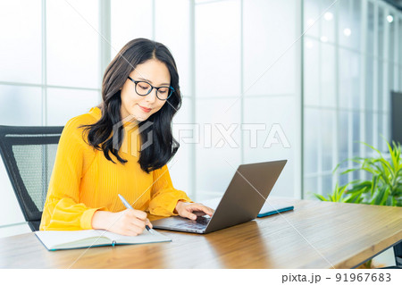 モダンなオフィスでノートパソコンを使う女性 モダンなオフィスでノートパソコンを使う女性 91967683