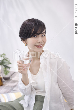 リビングで水を飲む若い女性 リビングで水を飲む若い女性 91967784