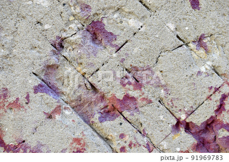 Plastered wall with red paint stones and cracks 91969783