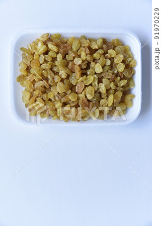 Juicy yellow raisins on a white backing 91970229