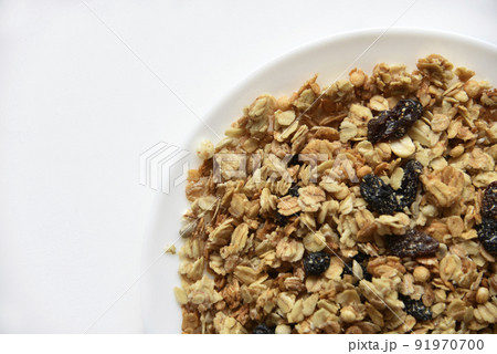 Muesli with nuts and raisins on a white plate 91970700