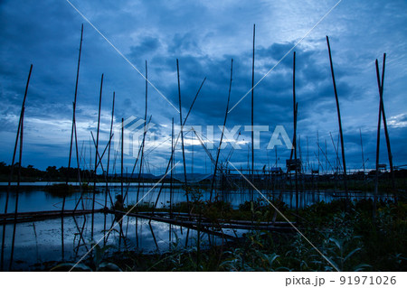 Traditional fishing tool or bamboo fish trap on sunset light, landscape silhouette. Traditional fishing tool or bamboo fish trap on sunset light, landscape silhouette. 91971026