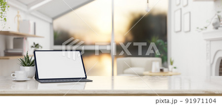 Modern workspace tabletop with tablet and copy space over blurred modern elegance living room. 91971104