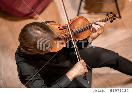 a violinist plays at a concert in the Philharmonic a violinist plays at a concert in the Philharmonic 91971186