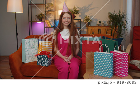 Happy child girl kid hold birthday gift box with ribbon, celebrating party, opening present at home Happy child girl kid hold birthday gift box with ribbon, celebrating party, opening present at home 91973085