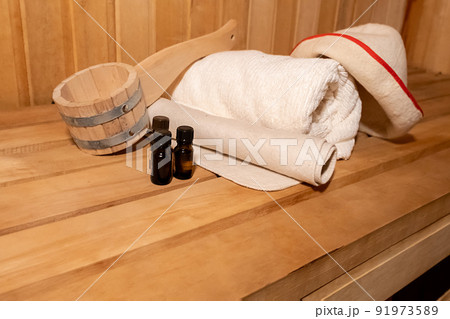 Traditional old Russian bathhouse SPA Concept. Interior details Finnish sauna steam room with traditional sauna accessories set basin towel aroma oil scoop felt. Relax country village bath concept 91973589