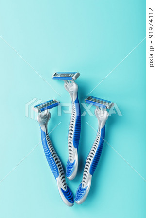 Blue shaving machines in a row on a blue background with ice cubes Blue shaving machines in a row on a blue background with ice cubes 91974112