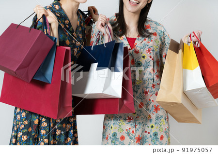 白背景のショッピングを楽しむミドルエイジの女性2人 91975057
