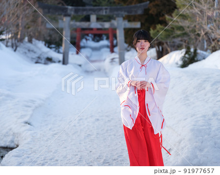 冬の参道を歩く巫女さん 91977657