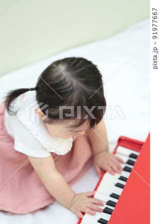 トイピアノのオモチャで遊ぶ1歳の女の子 91977667