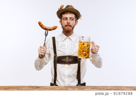 Portrait of Oktoberfest young emotional man in hat, wearing the traditional Bavarian clothes, holding beer mug. Alcohol, traditions, holidays, festival concept. Portrait of Oktoberfest young emotional man in hat, wearing the traditional Bavarian clothes, holding beer mug. Alcohol, traditions, holidays, festival concept. 91979288