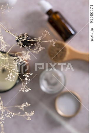 Skin care product for oil face massage and flowers on white table. Selective focus. Eco friendly organic reusable self care accessories. Skin care product for oil face massage and flowers on white table. Selective focus. Eco friendly organic reusable self care accessories. 91980271