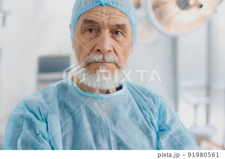 Professional senior surgeon in uniform standing in operating room, ready to work on patient Professional senior surgeon in uniform standing in operating room, ready to work on patient 91980561