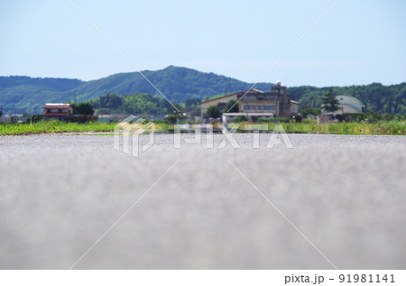 夏の炎天下のアスファルト路面に陽炎ができている光景 91981141