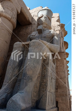Crumbling statue of a pharaoh on an ancient temple in Egypt 91983527