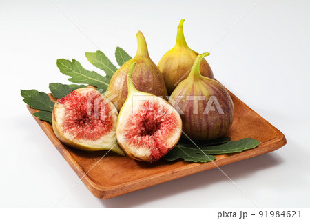 白バックで木の皿に乗せたイチジク 91984621