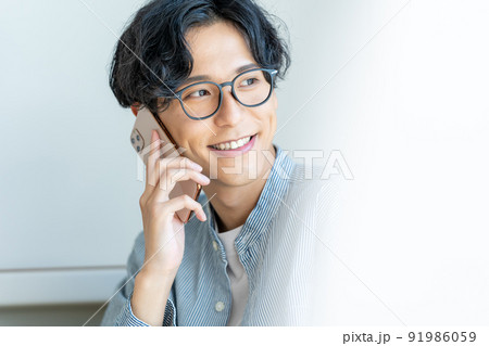 スマホで電話する若い男性 スマホで電話する若い男性 91986059