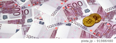 Bitcoins over pile of five hundred euro banknotes. Traditional money versus cryptocurrency concept. Gold coin above 500 euro bills. Close up Bitcoins over pile of five hundred euro banknotes. Traditional money versus cryptocurrency concept. Gold coin above 500 euro bills. Close up 91986480