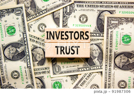 Investors trust symbol. Concept words Investors trust on wooden blocks on a beautiful background from dollar bills. Business invest and investors trust concept, copy space. 91987306