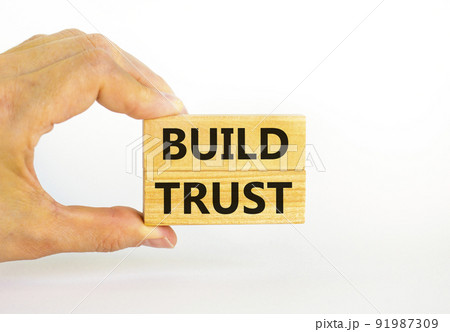 Build trust symbol. Concept words Build trust on wooden blocks on a beautiful white table white background. Businessman hand. Business and build trust concept, copy space. Build trust symbol. Concept words Build trust on wooden blocks on a beautiful white table white background. Businessman hand. Business and build trust concept, copy space. 91987309