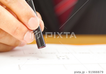 書類に印鑑を押すスーツ姿の男性の手元 書類に印鑑を押すスーツ姿の男性の手元 91988879