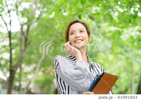 新緑の中で微笑む女性 91991003