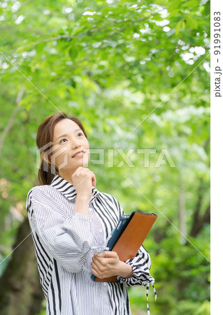 新緑の中で微笑む女性 新緑の中で微笑む女性 91991083
