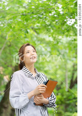 新緑の中で微笑む女性 新緑の中で微笑む女性 91991084