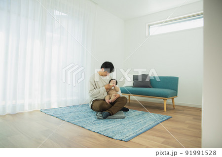 赤ちゃんにミルクをあげるパパ 91991528