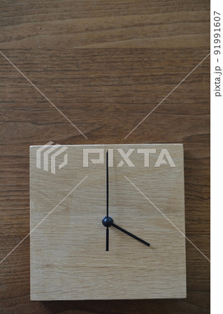 無垢の木材を使った、4時を示している掛け時計 91991607