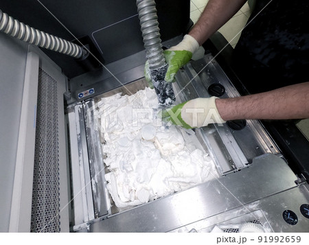 Engineer or artist designer printing 3D parts and shaping models from dust 3D print. Sculpting, creating, making. New 3D printing technologies. Multi Jet Fusion. Advanced additive technology in use. 91992659