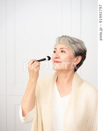 Portrait of mature asian woman 50s with holding make up brush. 91992797