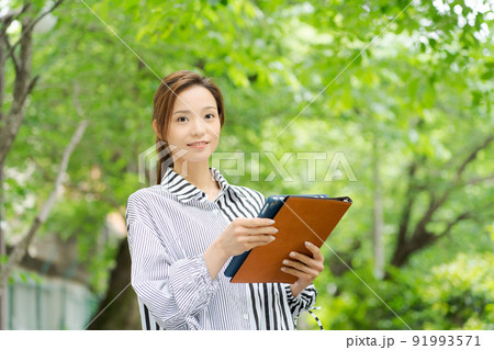 新緑の中で微笑む女性 新緑の中で微笑む女性 91993571
