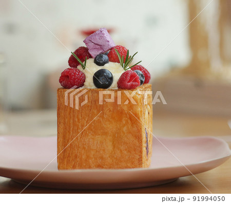 cube formed dessert with cream, raspberry, blueberry and marshmallow topping closeup photo cube formed dessert with cream, raspberry, blueberry and marshmallow topping closeup photo 91994050