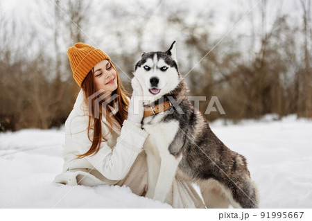 portrait of a woman winter clothes walking the dog in the snow winter holidays 91995667