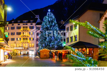 Night view of Brig street with Christmas tree on background of Alps, Switzerland 91996450