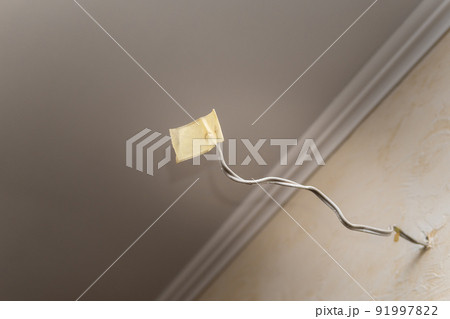Close-up of an insulated power cable on the wall of an apartment. Close-up of an insulated power cable on the wall of an apartment. 91997822