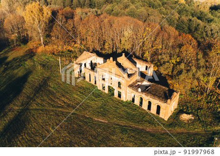 Bird's-eye view of ruins of the brewery in estate of the Tikhanovetskys. Aerial view of neo-gothic monument of industrial architecture of the early 20th century in autumn sunny day. Kanichi, Belarus Bird's-eye view of ruins of the brewery in estate of the Tikhanovetskys. Aerial view of neo-gothic monument of industrial architecture of the early 20th century in autumn sunny day. Kanichi, Belarus 91997968